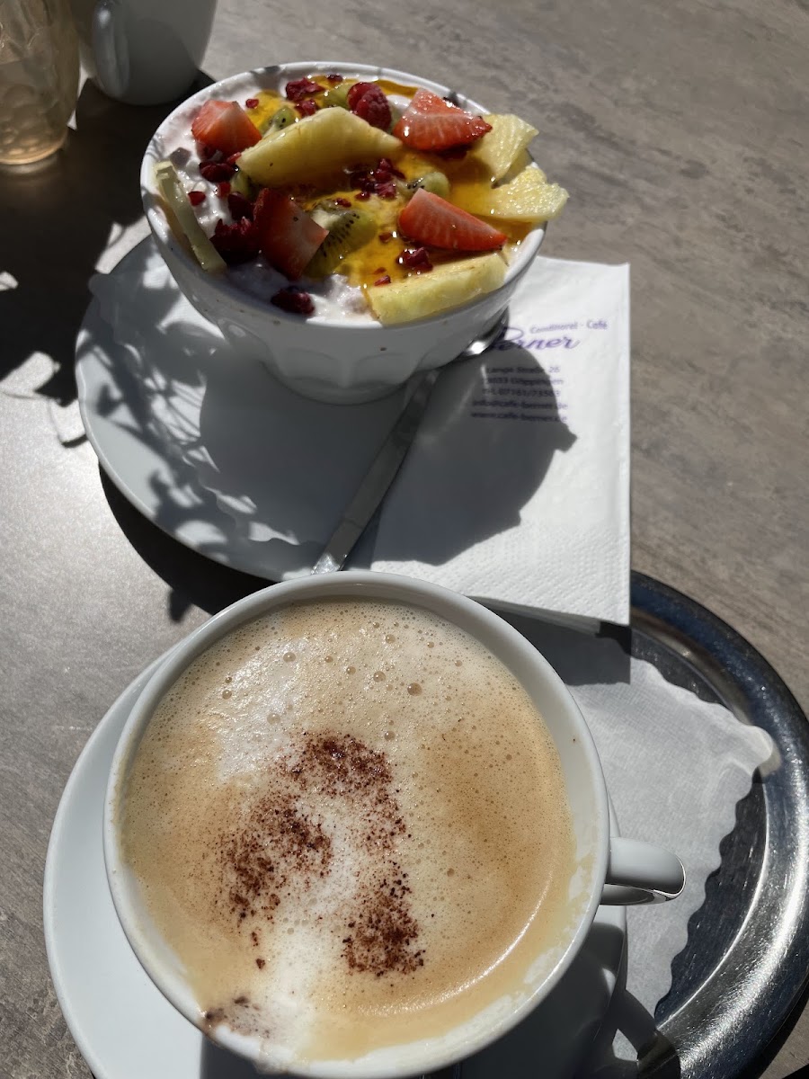 Frühstück mit Cappuccino und Joghurt-Obst-Schale auf der Terrasse des Café Berner